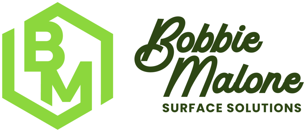 Hexagonal "BM" logo in green, next to "Bobbie Malone Surface Solutions" in stylized dark green text, representing a professional service brand.